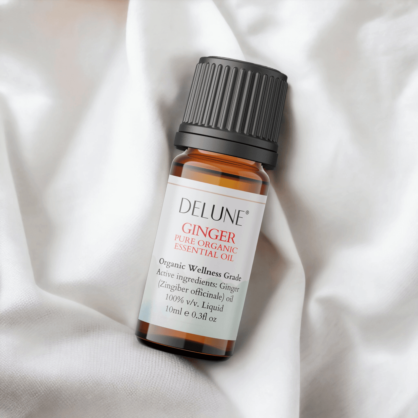 Ginger Organic Wellness Grade Essential Oil bottle on white fabric, 100% Zingiber officinale for vitality and energizing aroma.