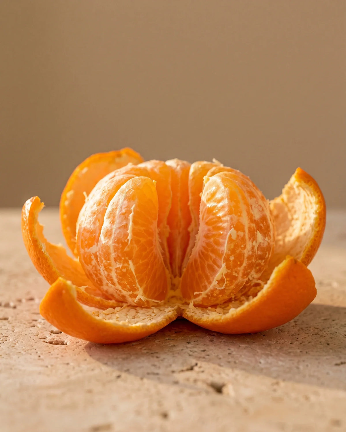 A freshly peeled mandarin with its segments glowing in warm light — the sweet, juicy citrus scent of Delune Mandarin Pure Essential Oil