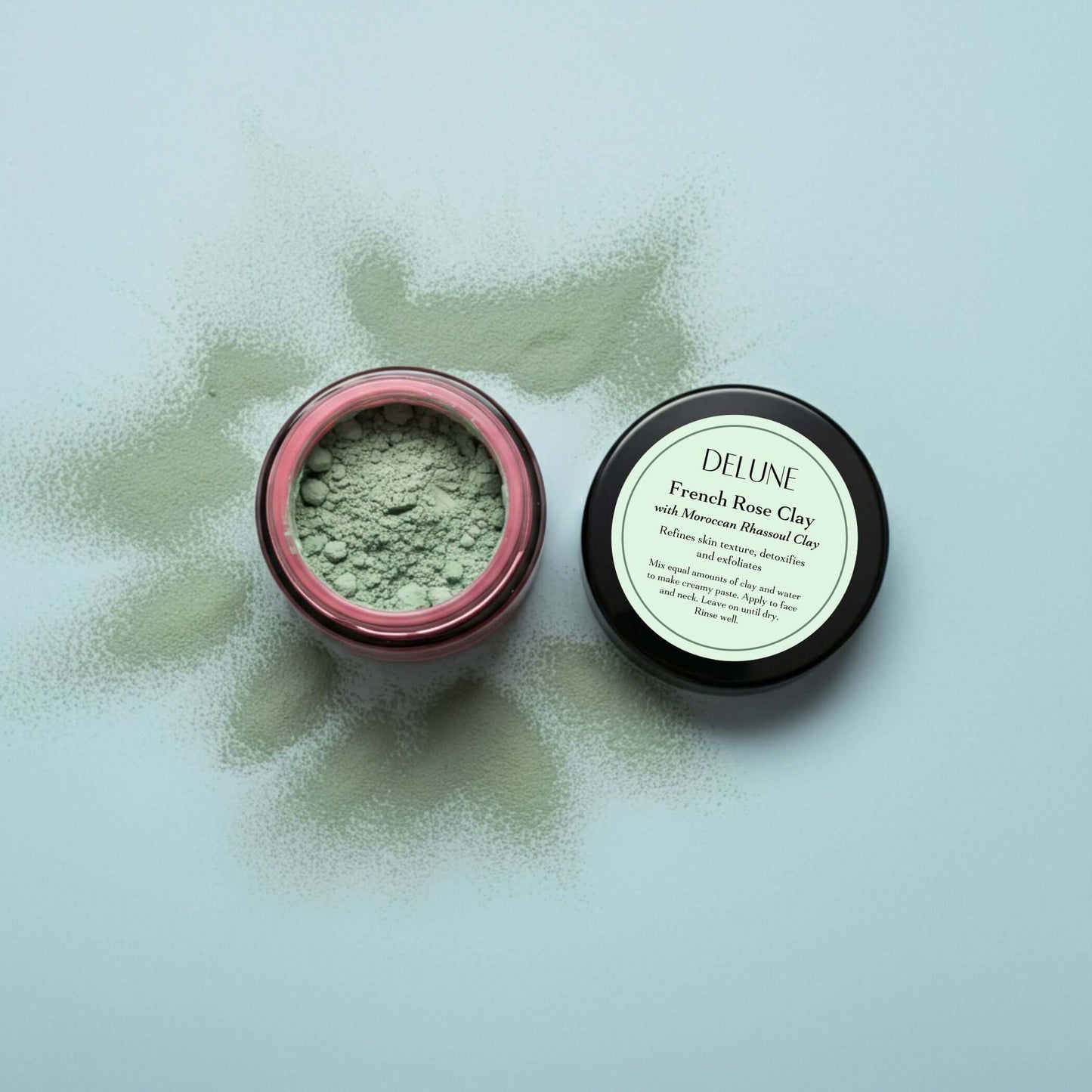 French Rose Clay Mask in open jar showcasing natural exfoliating powder with product label visible, ideal for clear and refreshed skin.