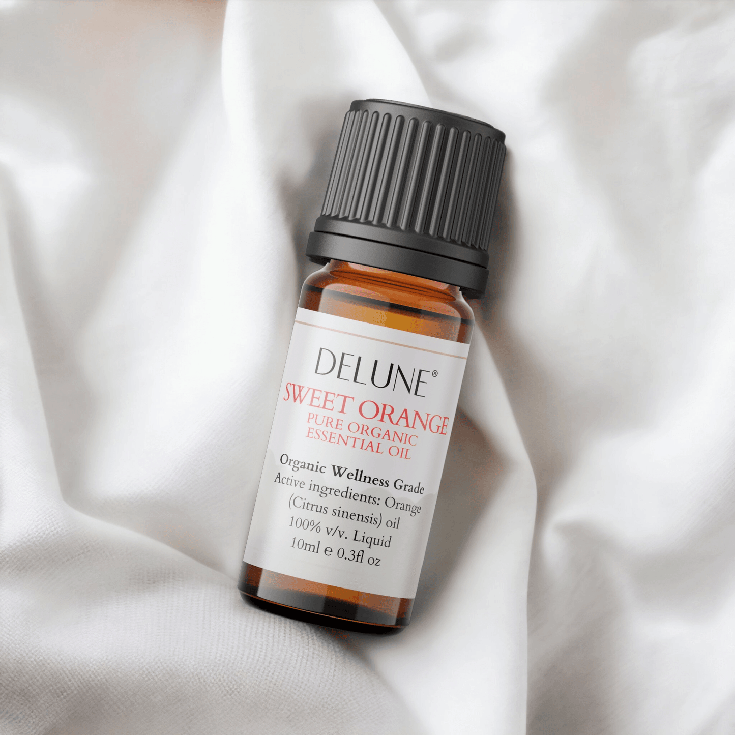 Sweet Orange Organic Wellness Grade Essential Oil bottle on soft white fabric, promoting positivity and cheerful citrus aroma.