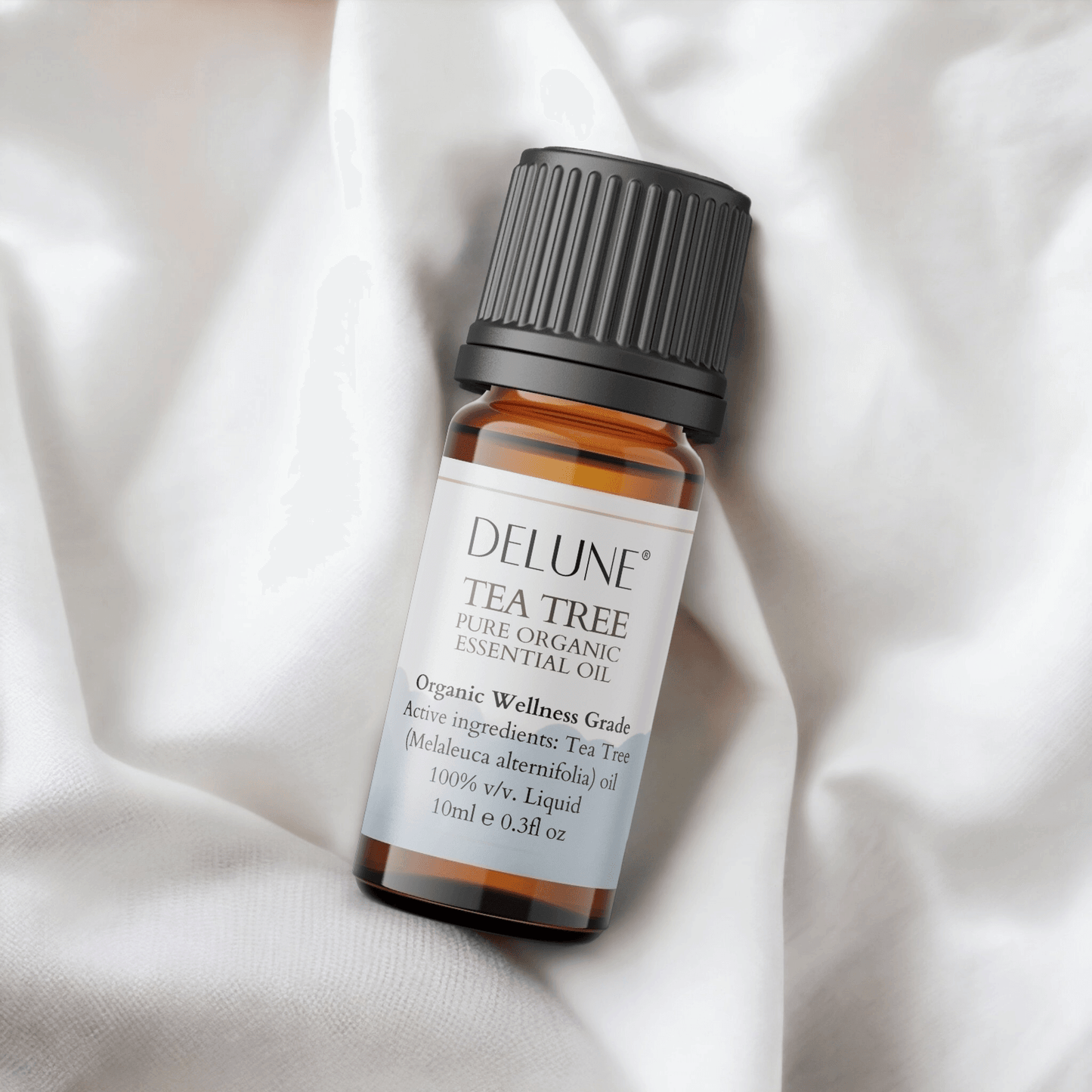 Tea Tree Organic Wellness Grade Essential Oil bottle on soft fabric.