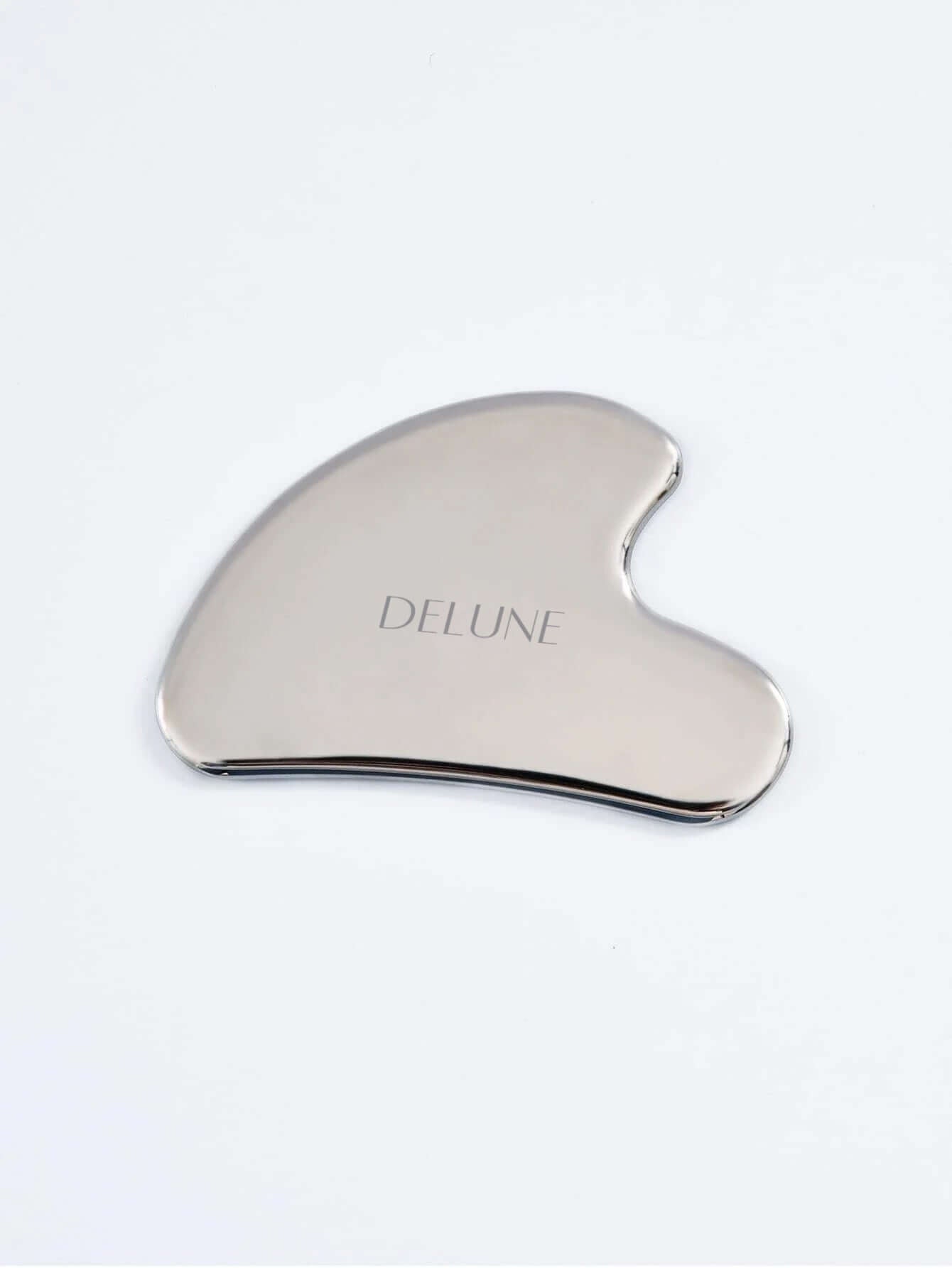 Deluxe stainless steel Gua Sha tool for natural facial contouring and skincare, engraved with brand name.