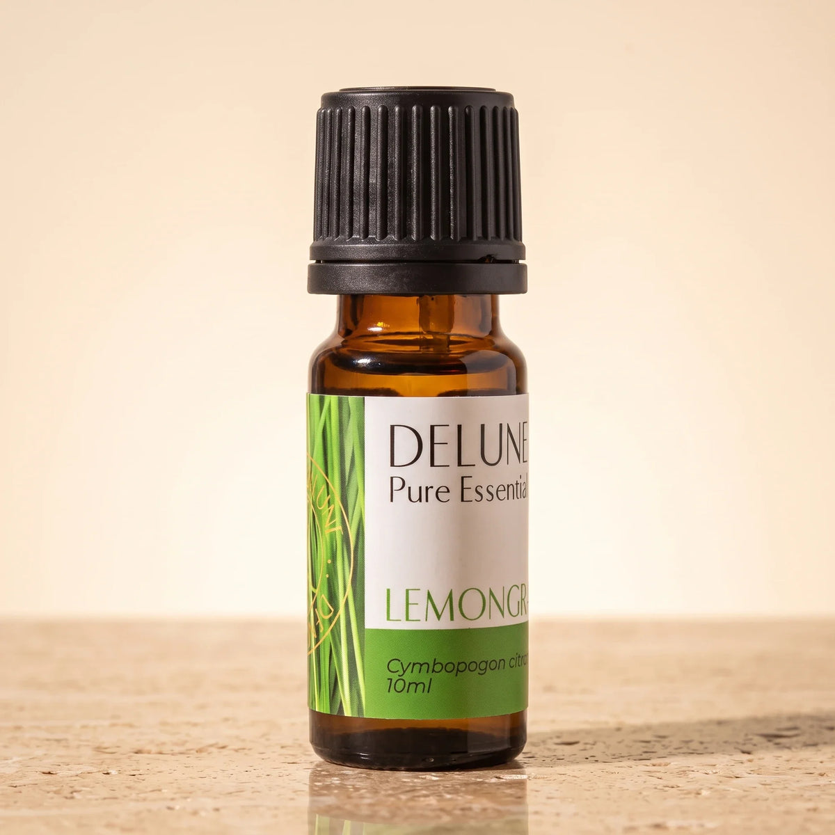 Delune Lemongrass Pure Essential Oil, 10ml amber glass bottle on warm travertine stone