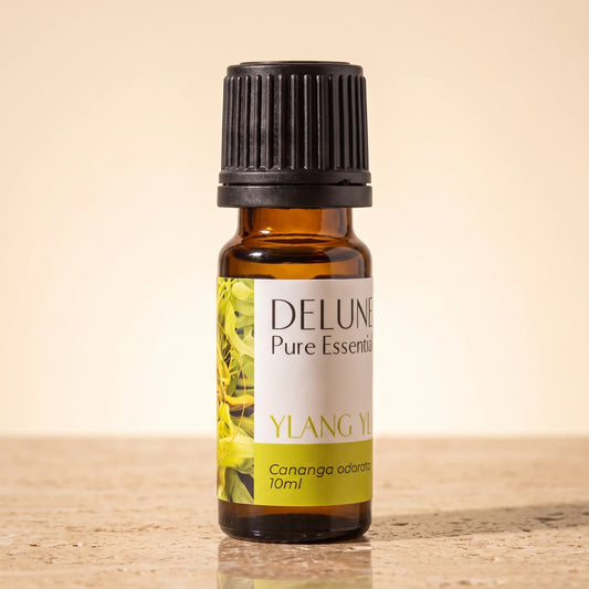 Delune Ylang Ylang Pure Essential Oil, 10ml amber glass bottle on warm travertine stone