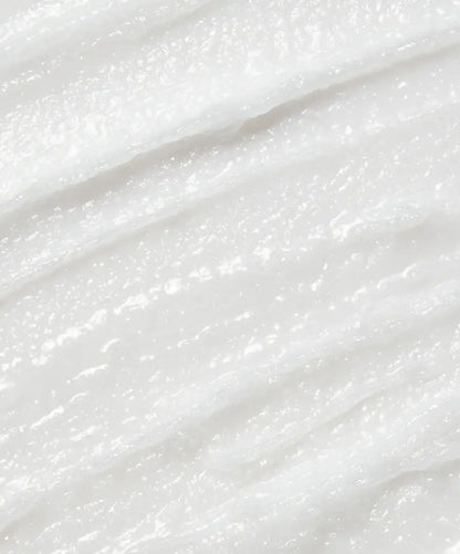 Close-up of creamy raw coconut cream cleanser texture, highlighting natural, unrefined virgin coconut oil and smooth consistency.